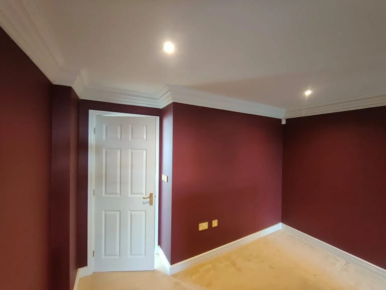White internal door and frame against deep red painted walls